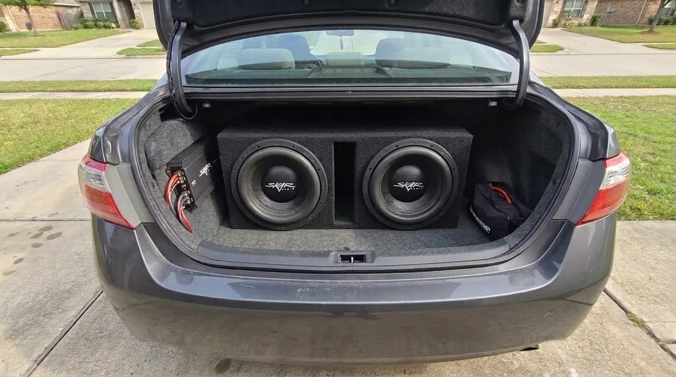Dual 12 inch ported subwoofer box installed in a sedan trunk